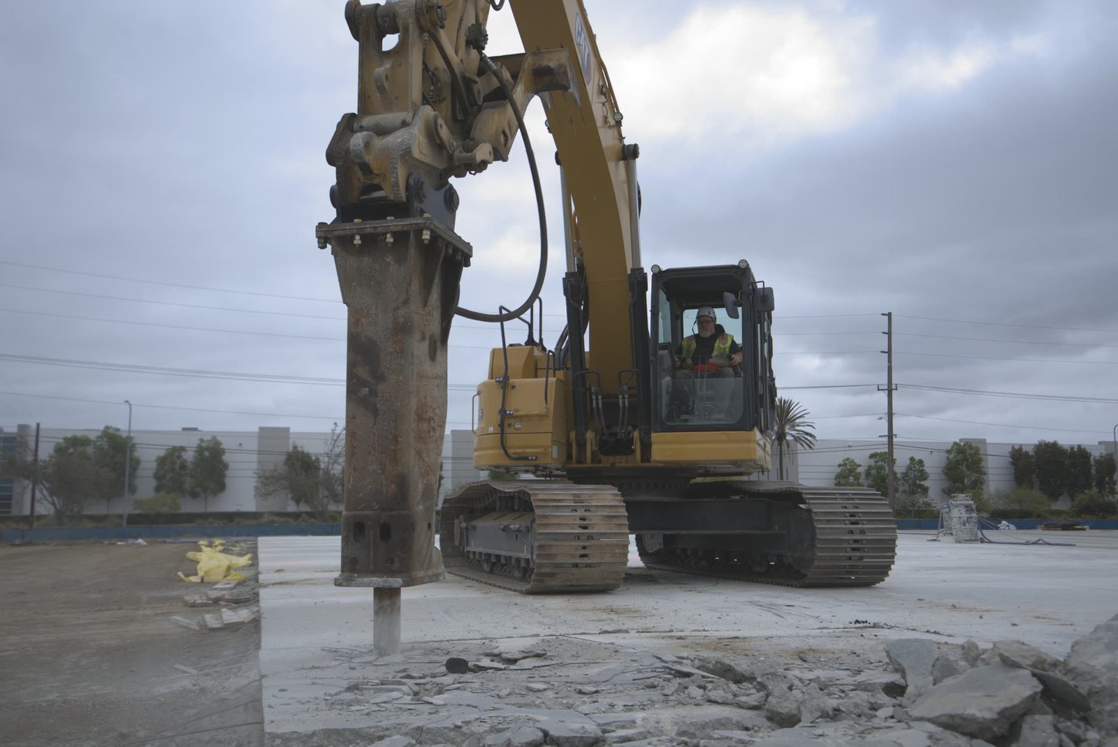 CAT excavator with hydraulic breaker demolishing concrete