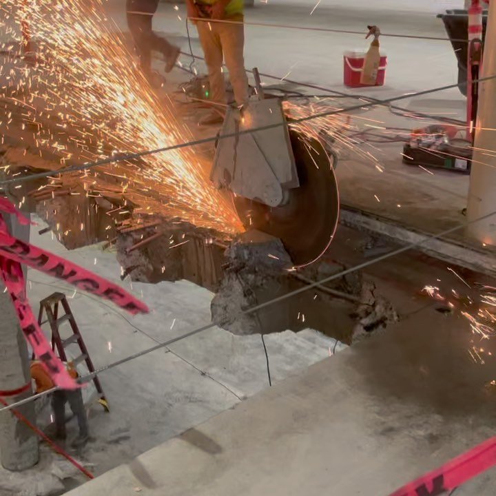 Diamond blade wall saw cutting through concrete with sparks